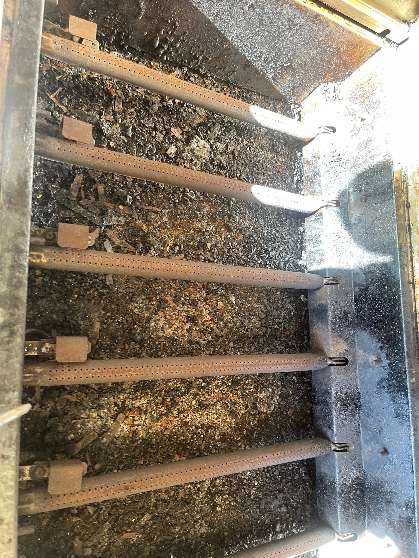 Grill interior showing accumulated grease and debris around the inside.